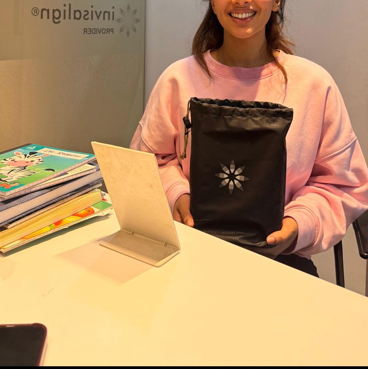 Patient collecting an Invisalign aligner kit at Studio Dental